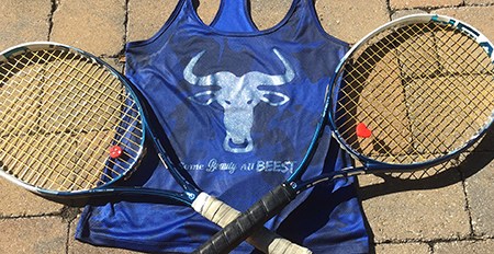 Two tennis rackets and a shirt with a wildebeest head and caption "Some beauty. All beest."