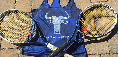 Two tennis rackets and a shirt with a wildebeest head and caption "Some beauty. All beest."